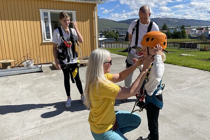 Staff member securing guests in safety gear.