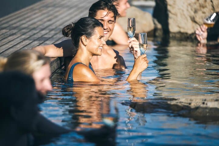 Enjoy a drink in the luxurious Hvammsvik Hot Springs while immersing yourself in this luxurious experience