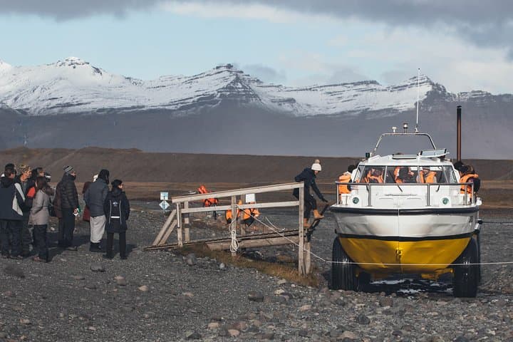Waterproof hiking boots and thermal layers with windproof clothing keep travelers on Iceland’s South Coast warm.